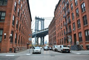 Brooklyn Bridge from street between 2 apartment buildings